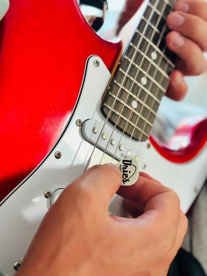 Plectrum met het logo van Dries Vanden Borre op een elektrische gitaar